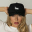 A person wearing a white t-shirt and a black director's hat with a white moonicorn logo on the front.